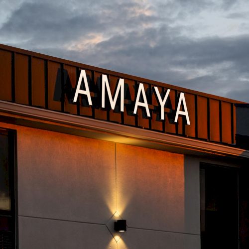 Illuminated Amaya hotel sign against evening sky